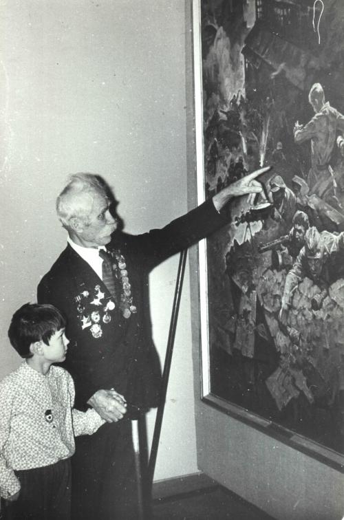 1990-е. Дедушка и внук перед картиной А.А. Прокопенко «Бой на тракторном заводе» (1982)